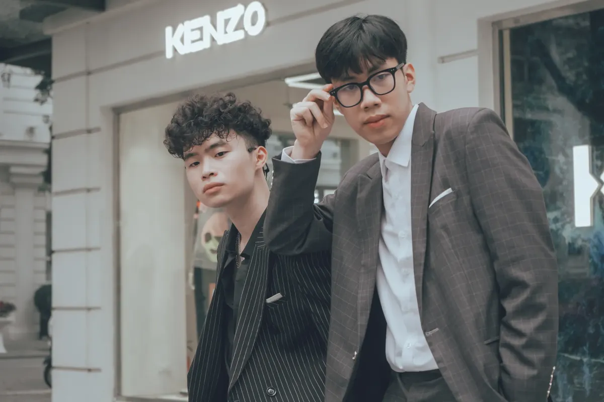 Two fashionable Asian men posing in front of a Kenzo store in Hanoi, Vietnam.