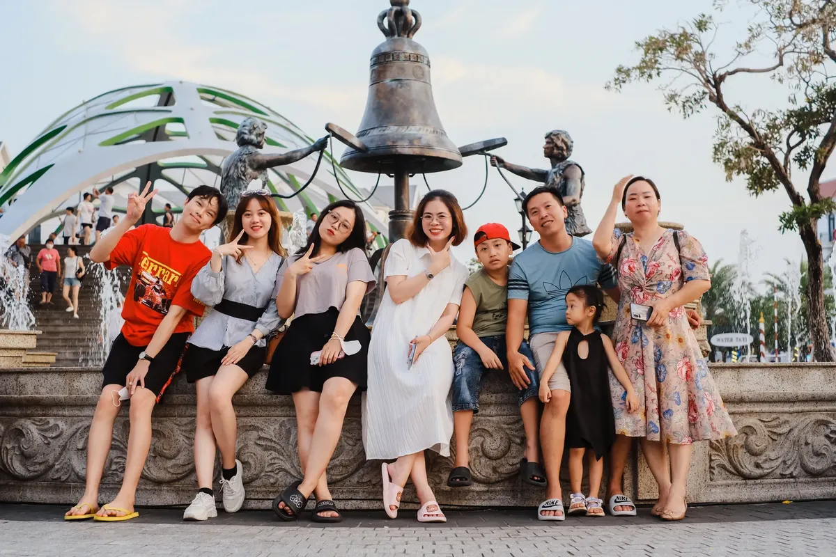 Group of happy friends and family posing near statue in Phu Quoc, Vietnam.