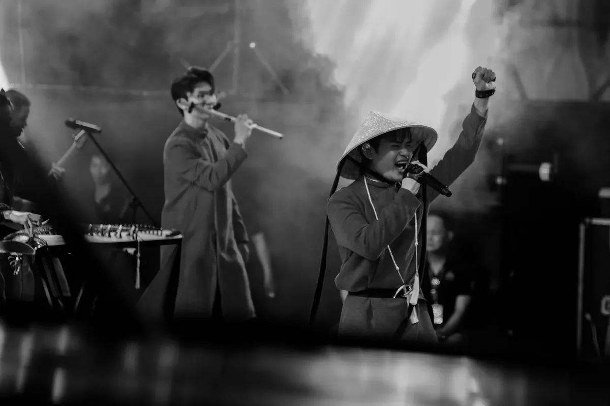 Black and white photo capturing a lively musical performance in Vietnam with vibrant energy.