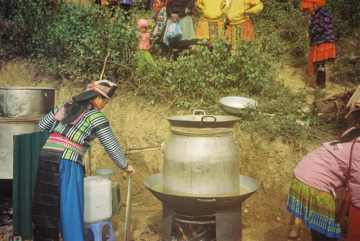 외부에서 전통적인 베트남 요리 활동을 하는 여성과 어린이.