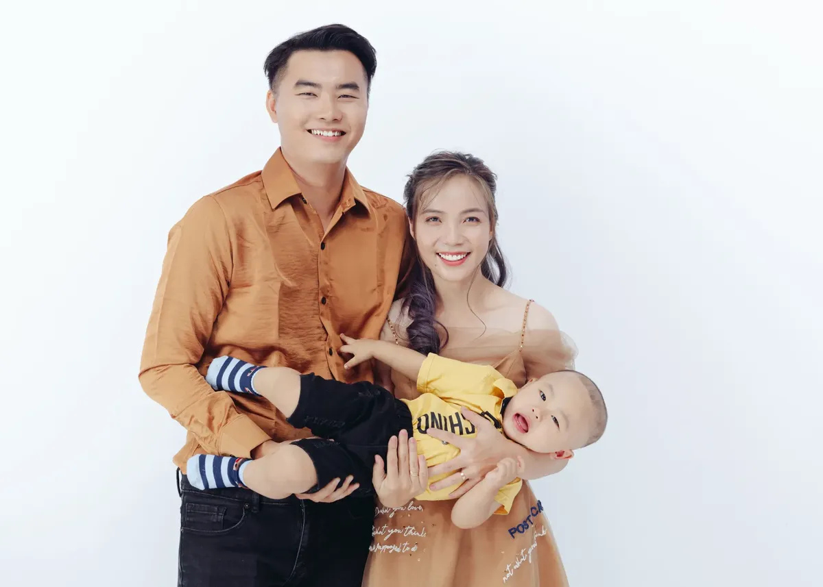微笑む家族に子供がいるカジュアルなスタジオ写真セッション、幸せと一体感を表現しています。