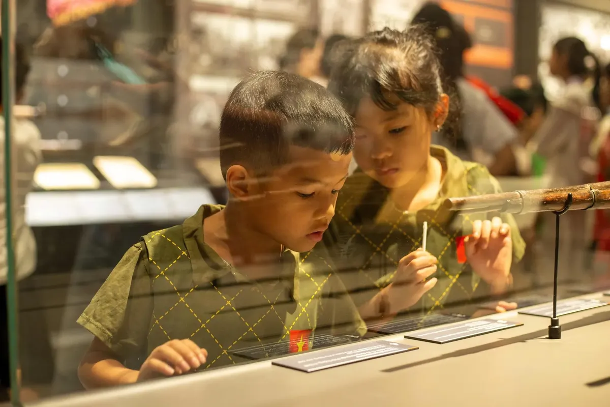 Engaged children exploring a museum exhibit in Hanoi, showcasing education and curiosity.