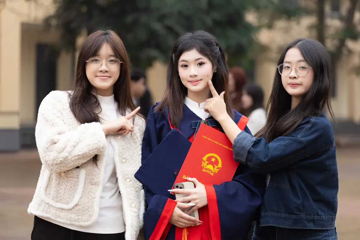 하노이, 베트남에서 세 명의 젊은 여자가 외부에서 졸업식을 축하하고 있다.