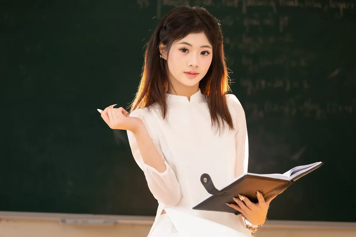 越南年輕女性穿著傳統服裝在河內教室裡學習。